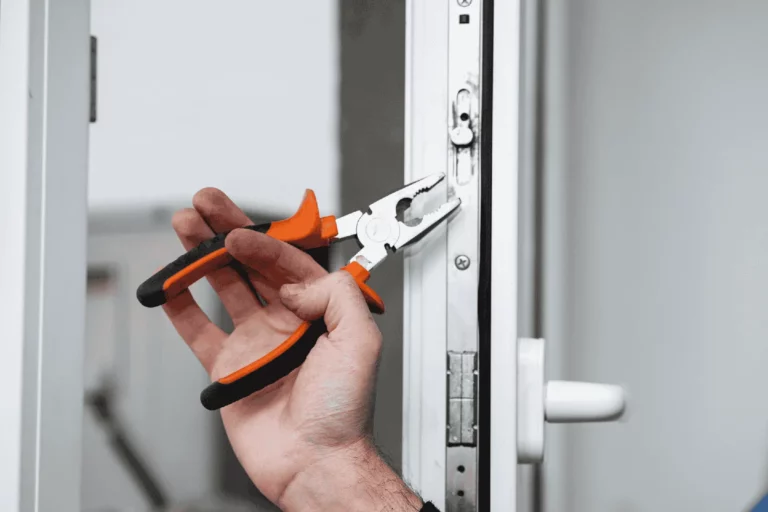 Workman fixing a PVC window mechanism with pliers